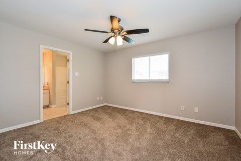a living room with carpet and a ceiling fan