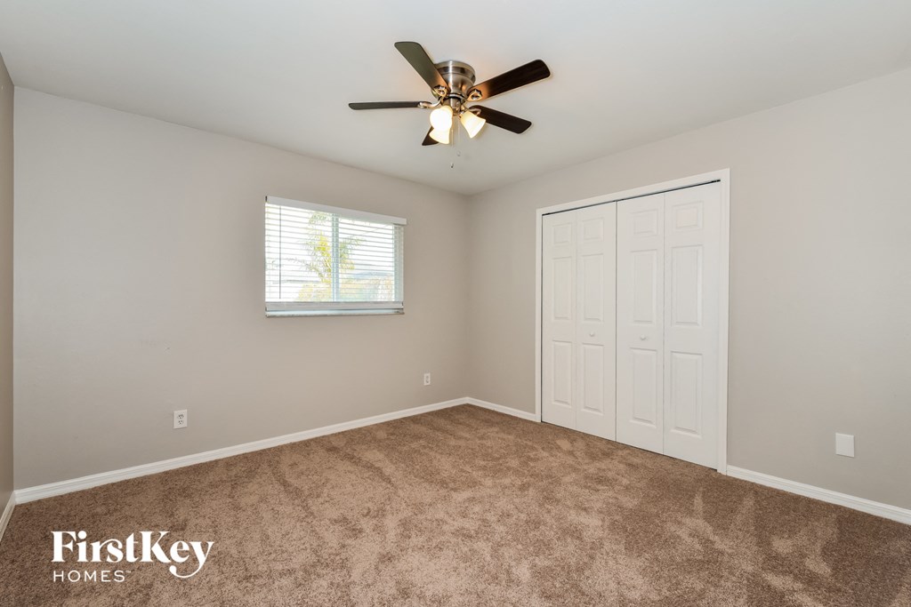 a bedroom with carpet and a ceiling fan