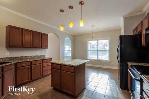 A kitchen with brown cabinets and a granite countertop.