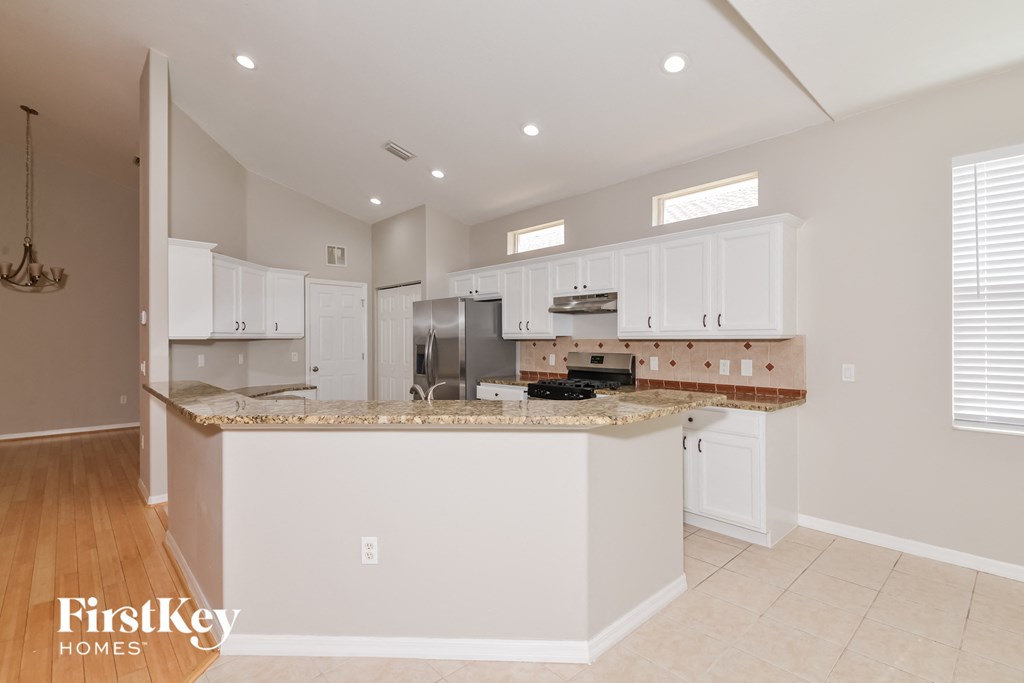 A kitchen with white cabinets and a countertop is shown.