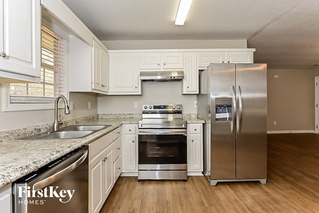 a kitchen with white cabinets and stainless steel appliances