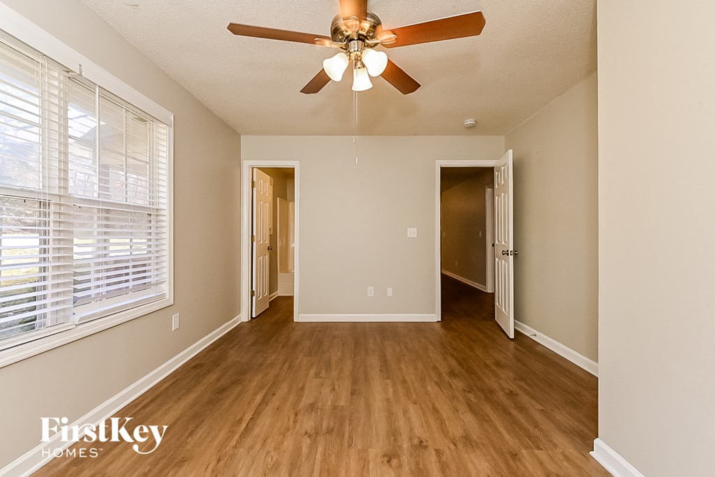 the living room of an empty house with a ceiling fan