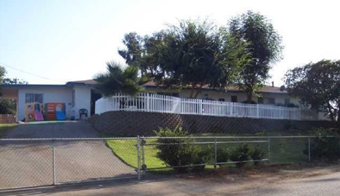 A white building with a white fence in front of it.