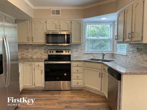 A kitchen with a stove top oven and a refrigerator.