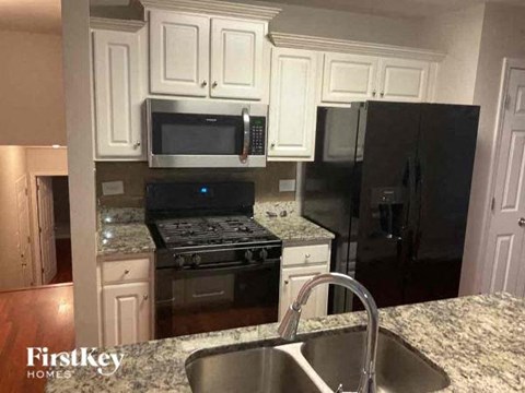 a kitchen with a sink a stove and a microwave