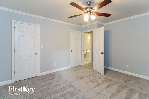 a bedroom with two closets and a ceiling fan