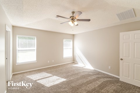 a living room with carpet and a ceiling fan