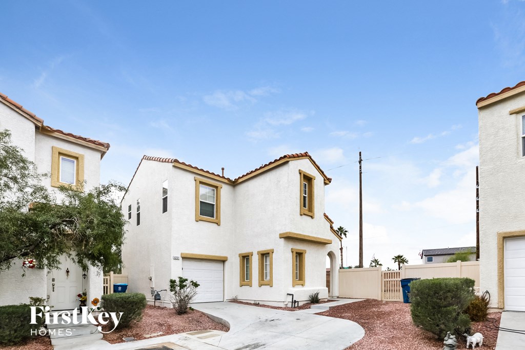 a white house with a driveway and a blue sky