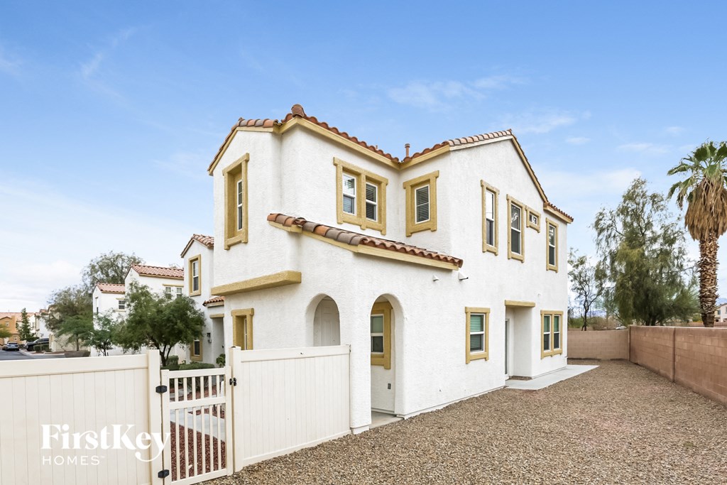 a white house with a white fence and a palm tree