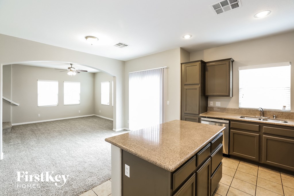 a kitchen and living room with a granite counter top