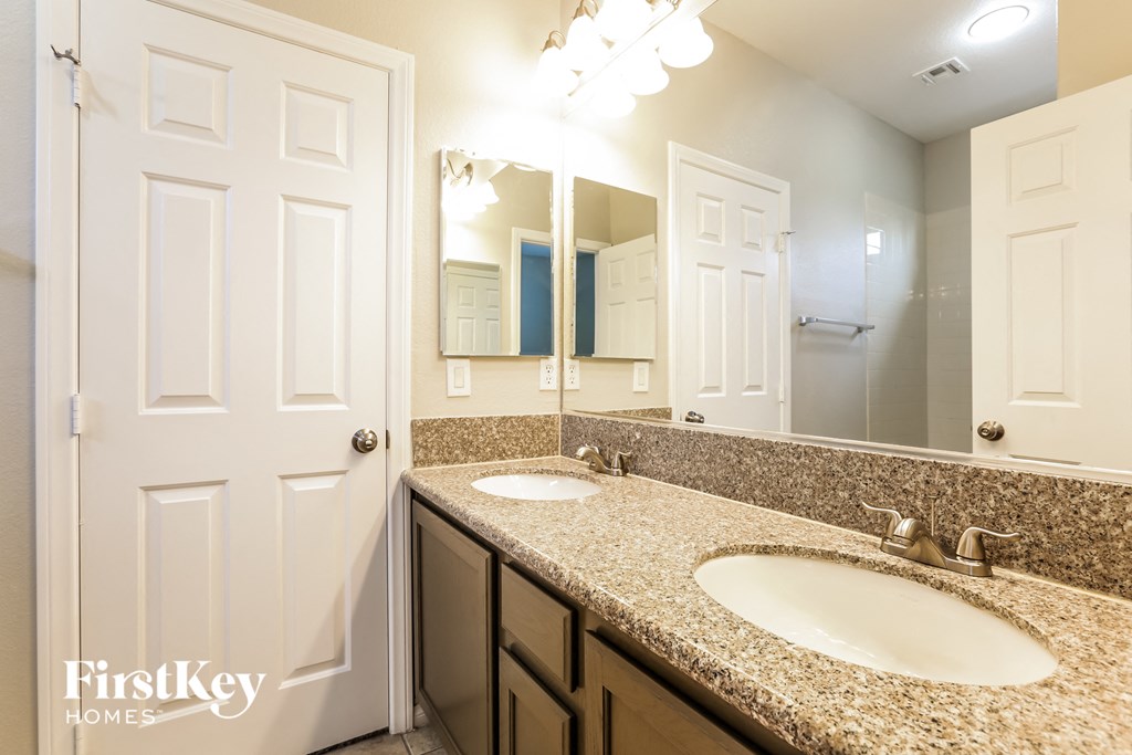 a bathroom with two sinks and a large mirror