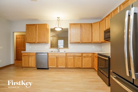 A kitchen with wooden cabinets and a stainless steel refrigerator.