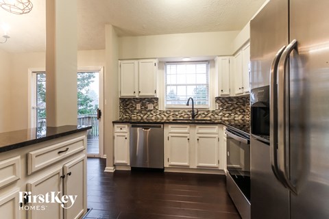 a kitchen with white cabinets and stainless steel appliances