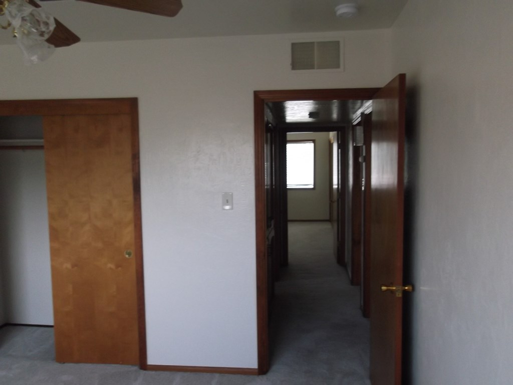 a view of the hallway from the living room into the bedroom and the bathroom