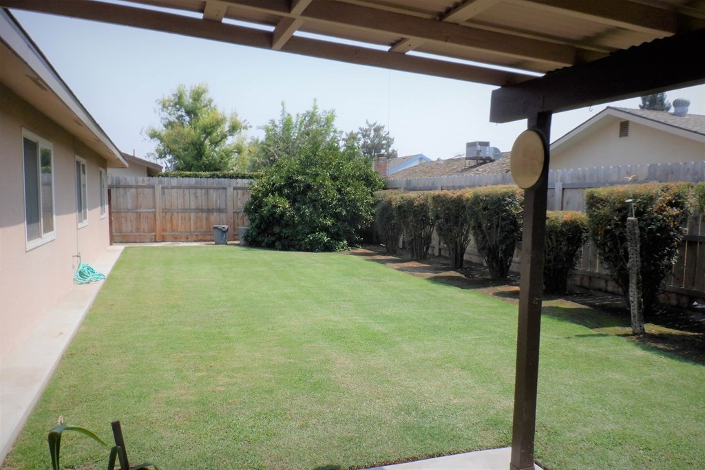 a backyard with a lawn and a fence