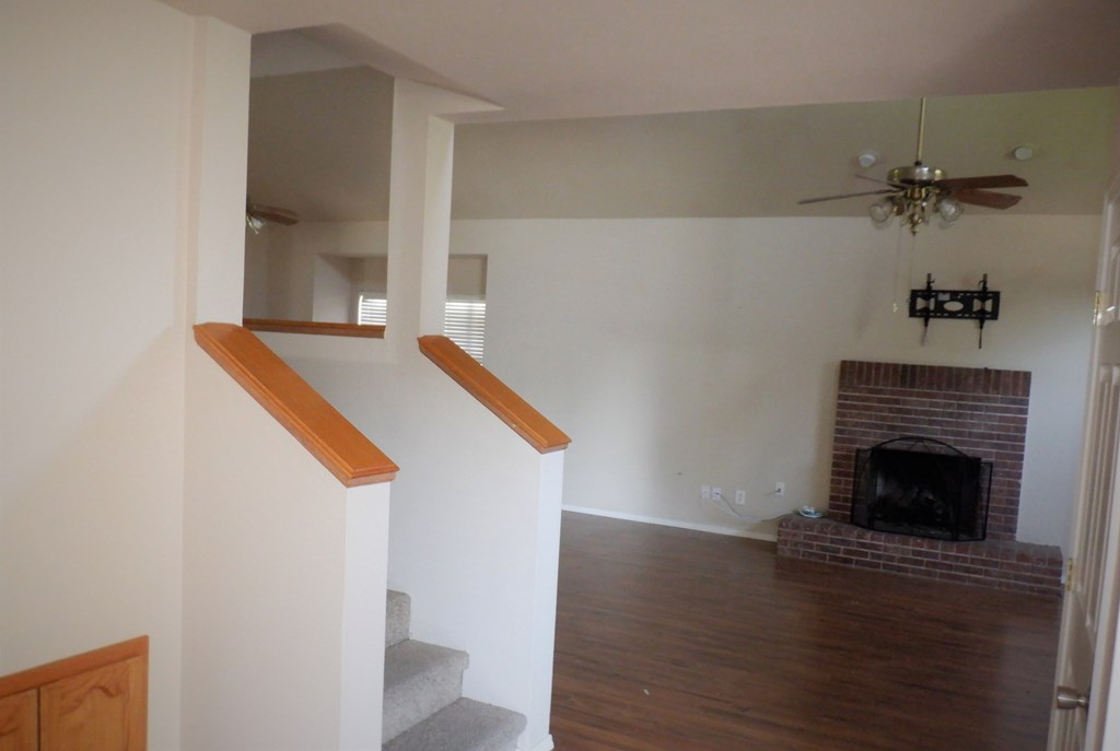 a view of the living room from the stairs with a fireplace