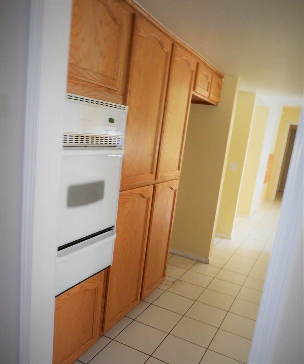 a kitchen with a white oven and cabinets