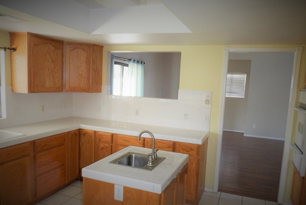 an empty kitchen with a sink and a mirror