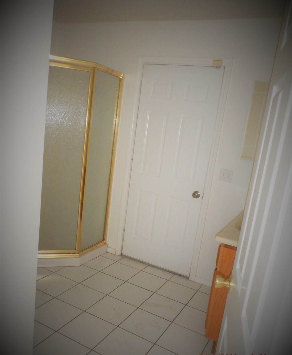 a small bathroom with a shower and a white door