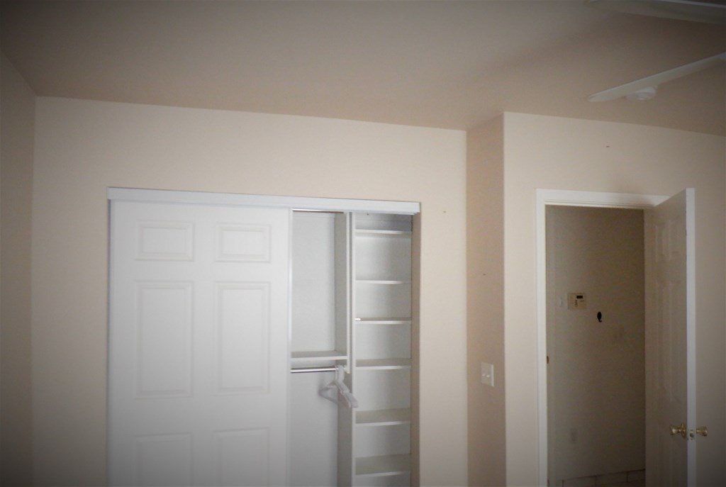 an empty room with a closet and a white door