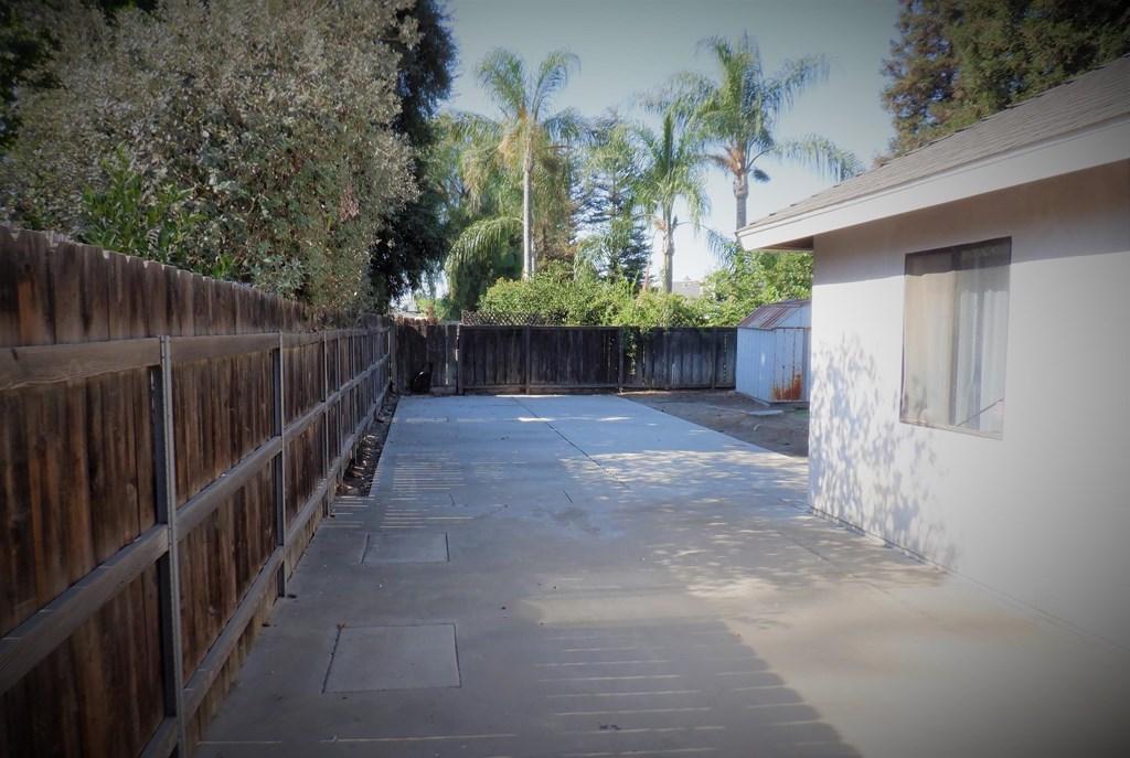 a patio with a fence and a house on it