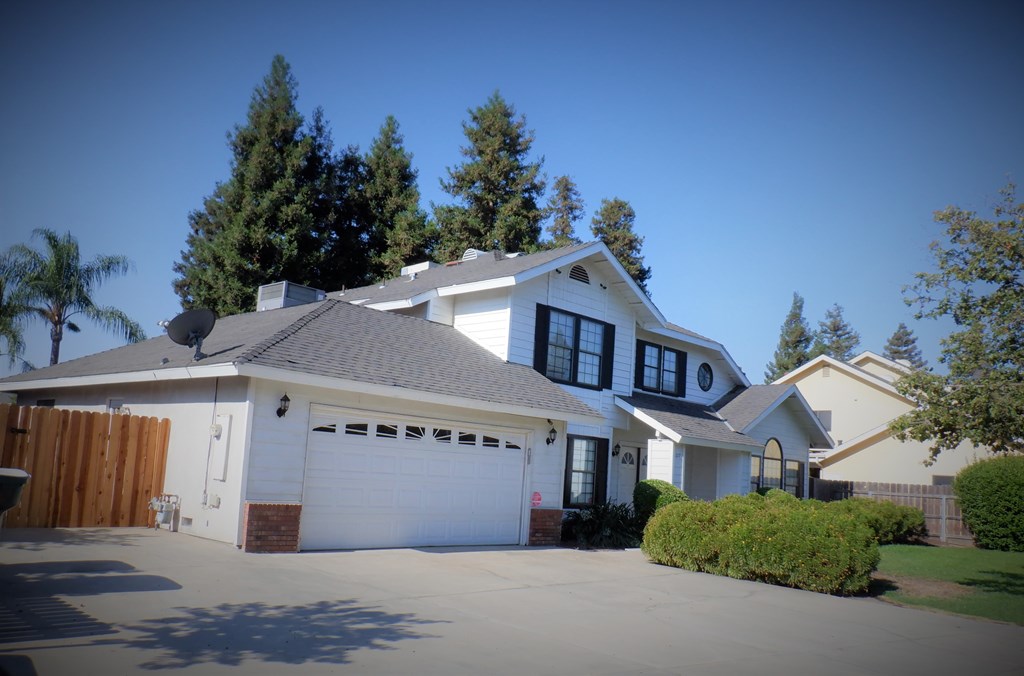a white house with a driveway and a garage door