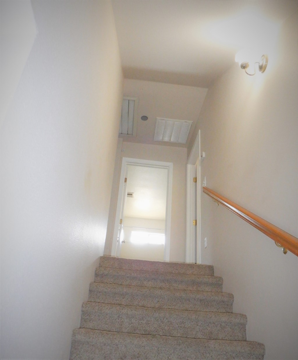 a view down the stairs of a hallway with a white door