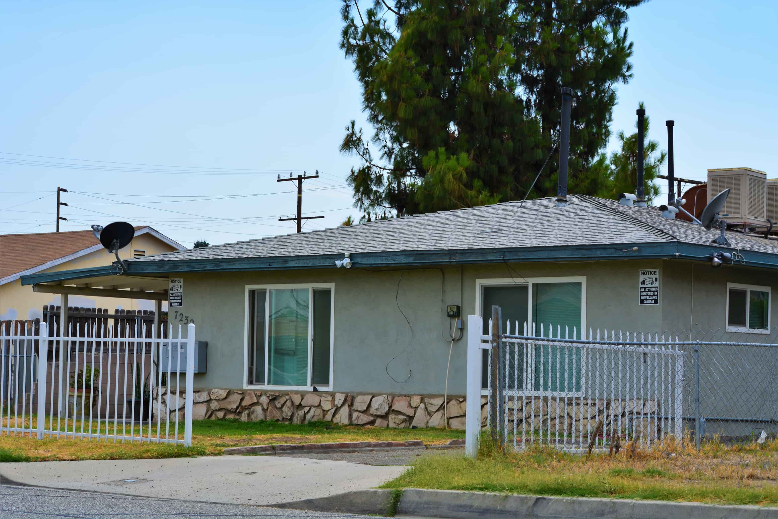a house with a white fence and a tree