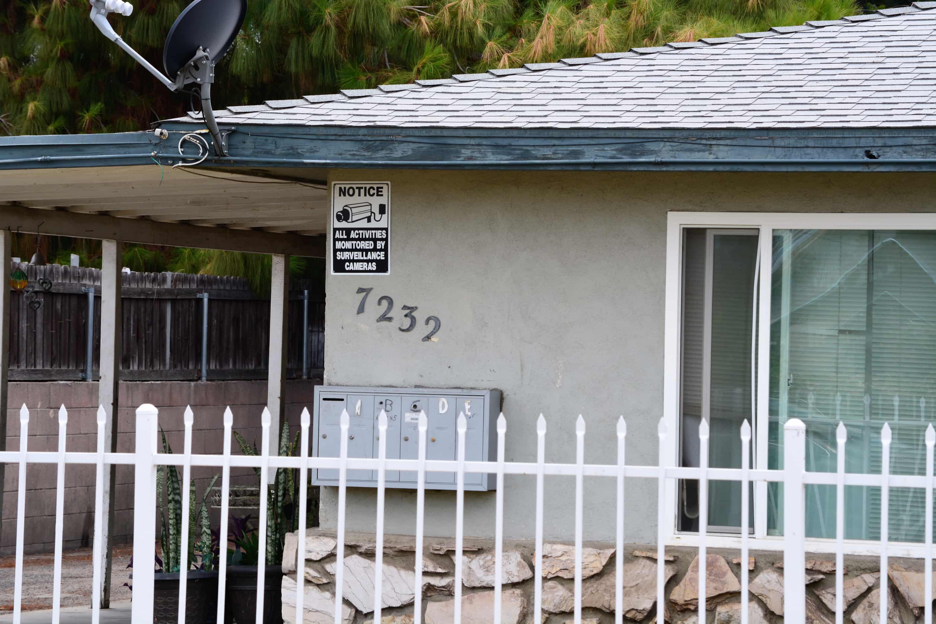 a house with a white fence and a sign on the side of it