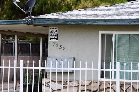 a house with a white fence and a sign on the side of it