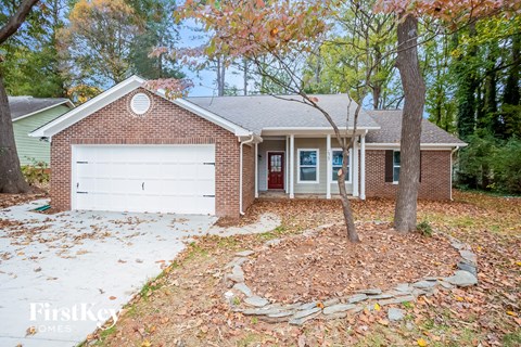 A brick house with a white garage door and a red door.