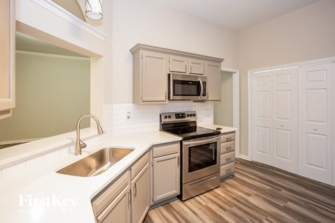 A kitchen with a stove, oven, microwave, and sink.