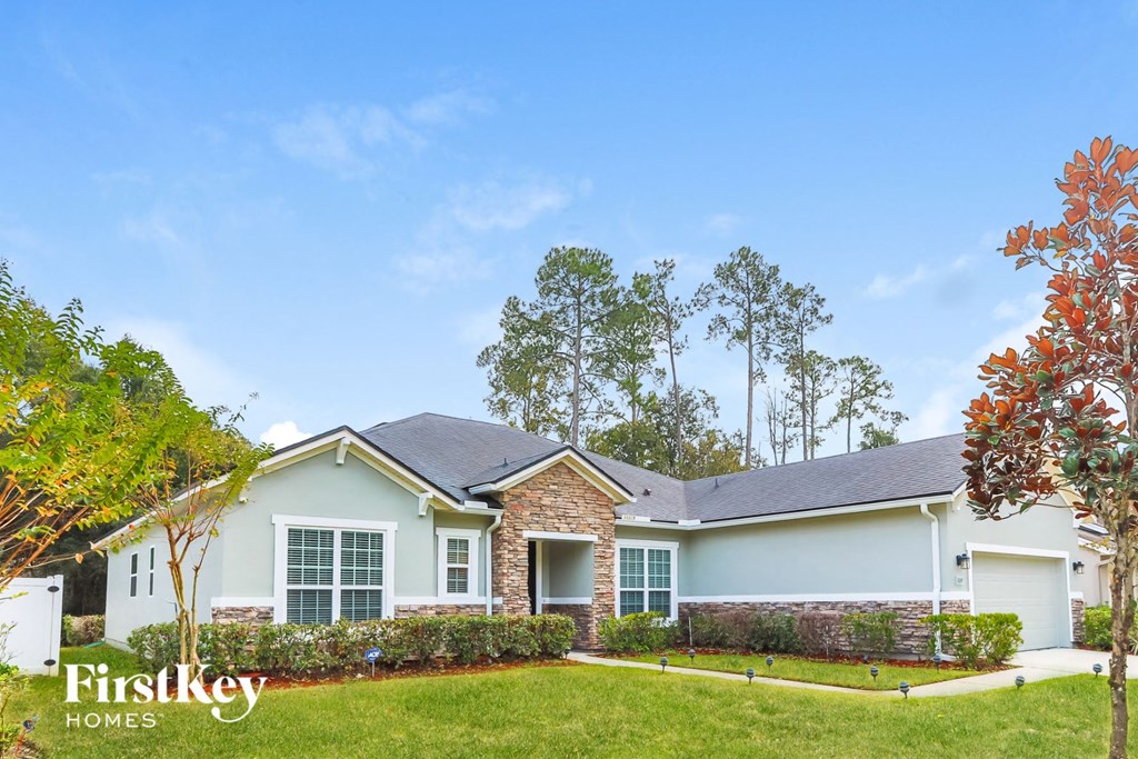 a house with a lawn and trees in front of it