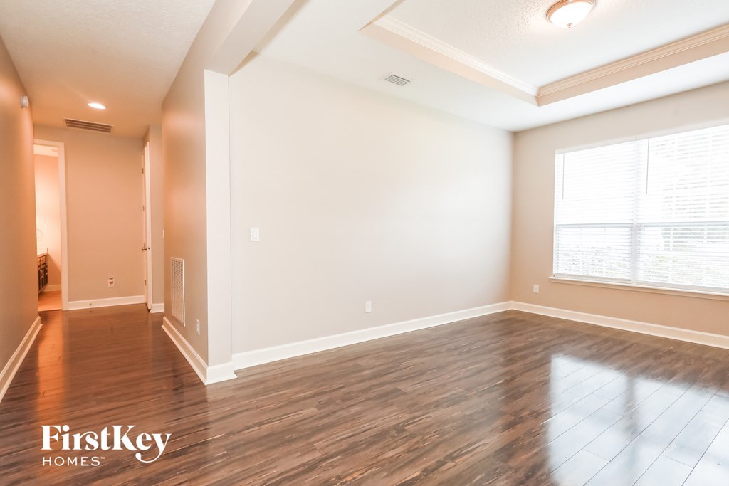 the living room and dining room with wood flooring and a large window