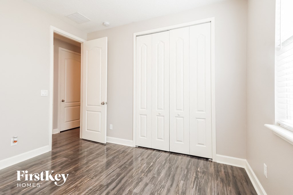 the living room of a new home with white doors and wood flooring