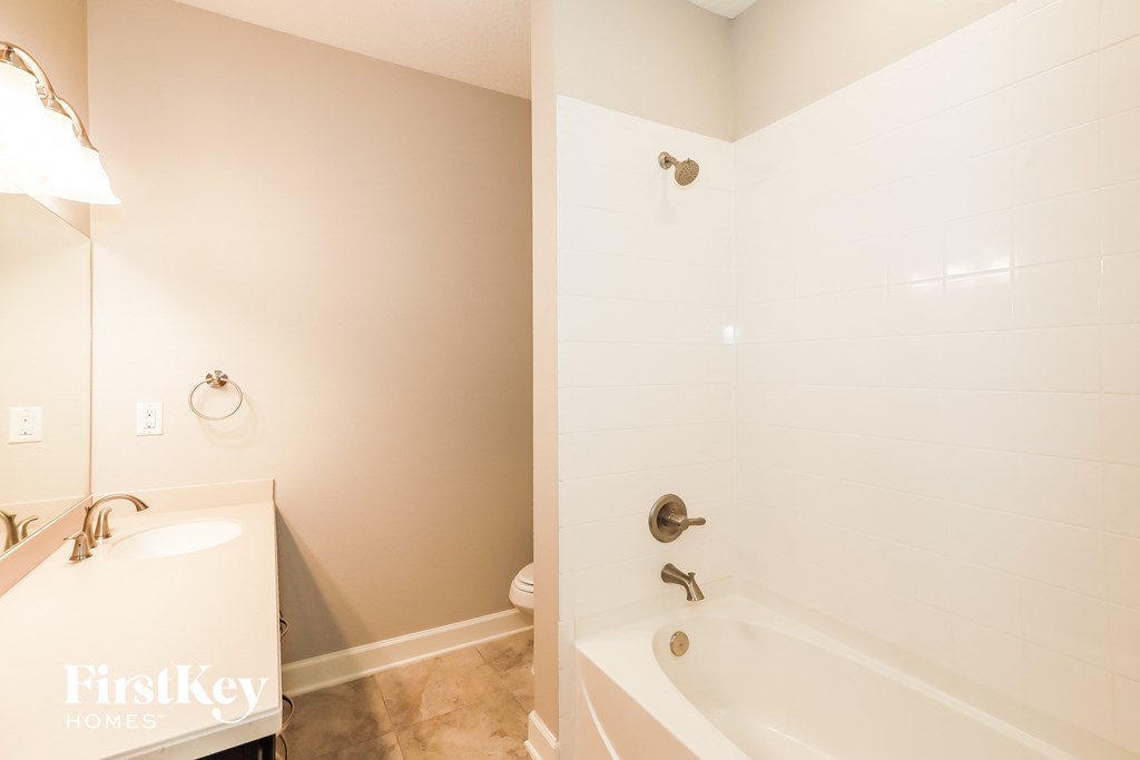 a bathroom with a tub and a sink and a toilet