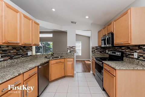 a kitchen with granite counter tops and wooden cabinets