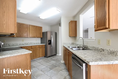 A kitchen with wooden cabinets and a marble countertop.