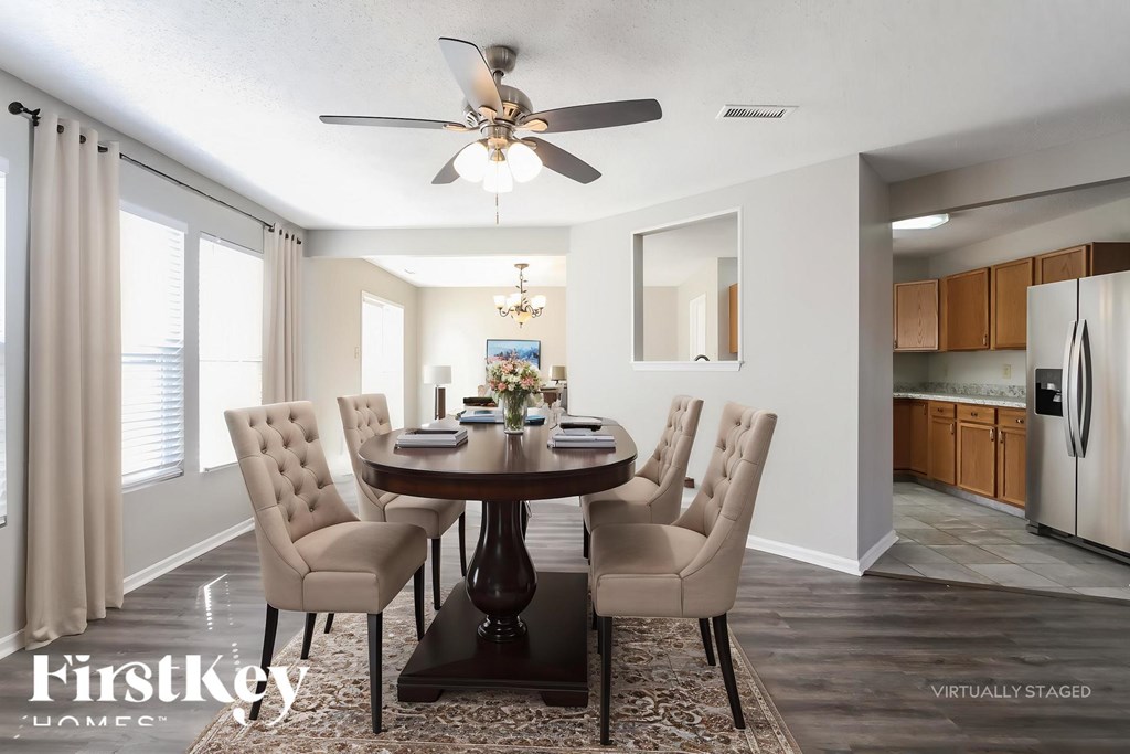 A dining room with a table set for six and a chandelier hanging from the ceiling.