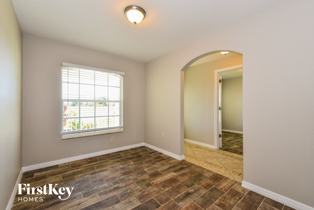 the spacious dining room with wood flooring and a large window