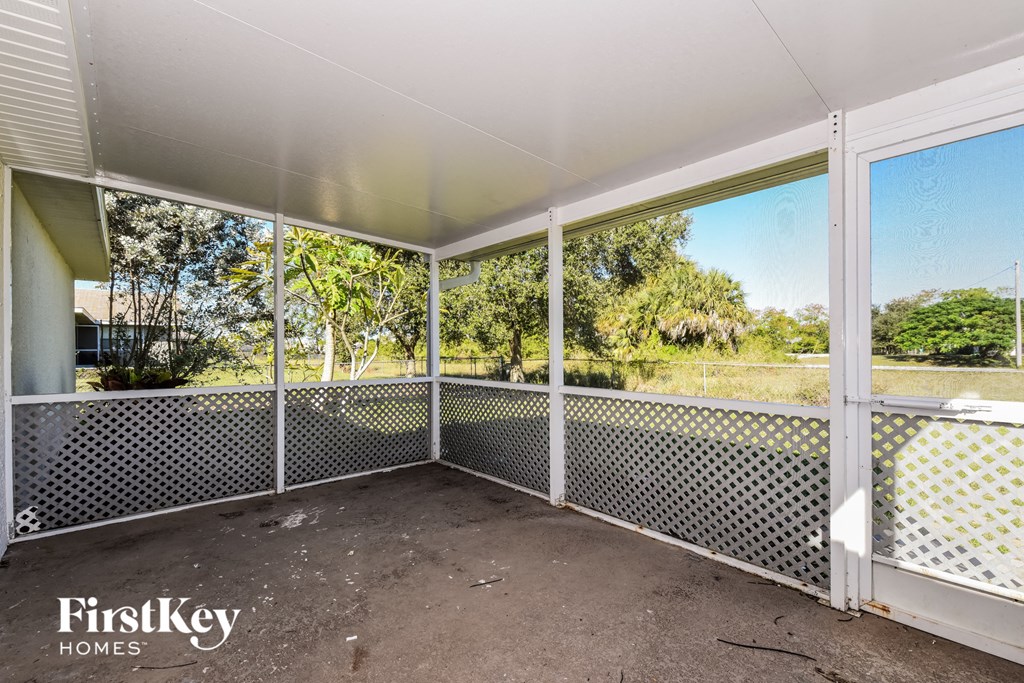a screened in porch with glass doors and a view of the yard