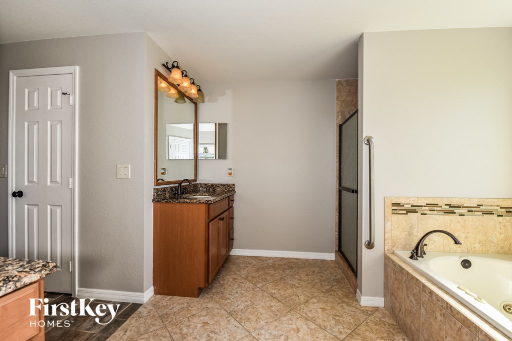 a bathroom with a large tub and a sink and a mirror