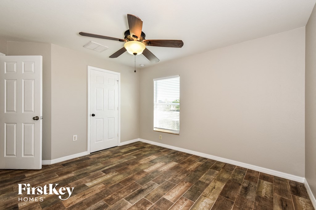 a living room with wood flooring and a ceiling fan