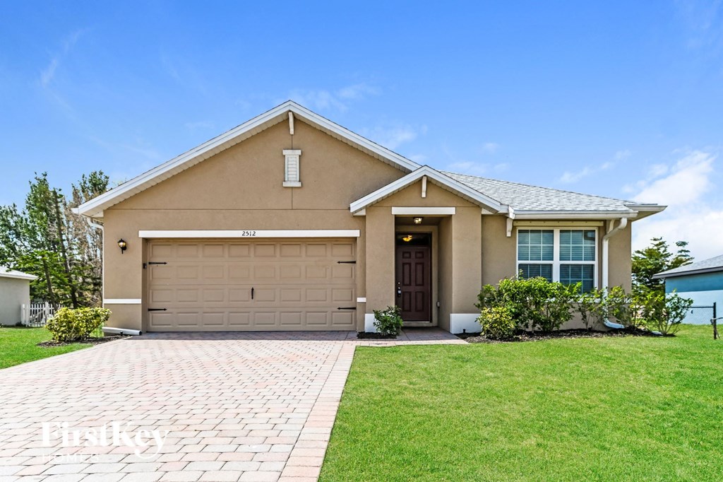 a beige house with a driveway and a garage door