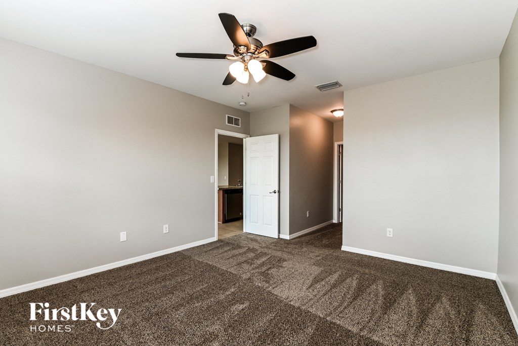 a living room with carpet and a ceiling fan