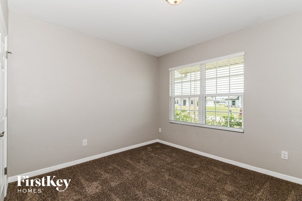 the living room of a home with carpet and a window