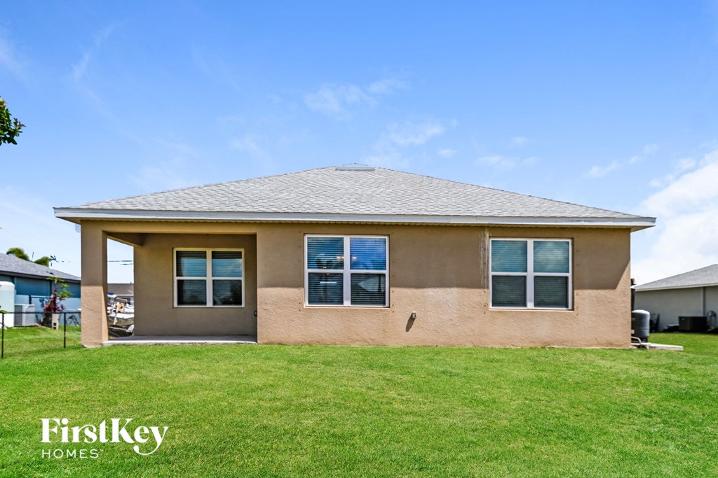 a tan brick house with a grassy yard