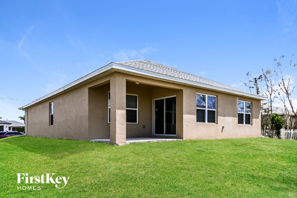 a brown house with a lawn and a blue sky