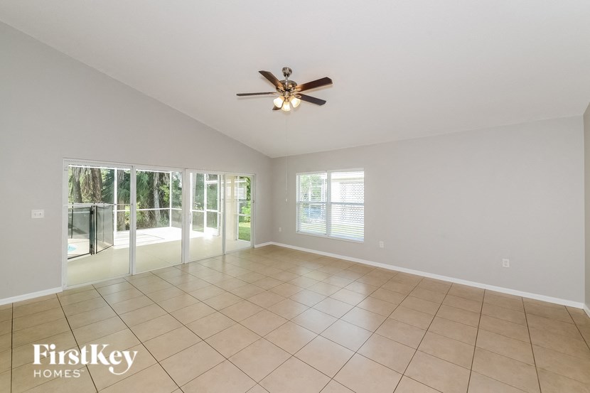 A spacious room with a ceiling fan and tiled floor.