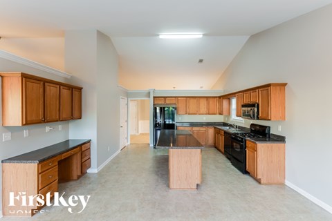 A kitchen with wooden cabinets and a black countertop.